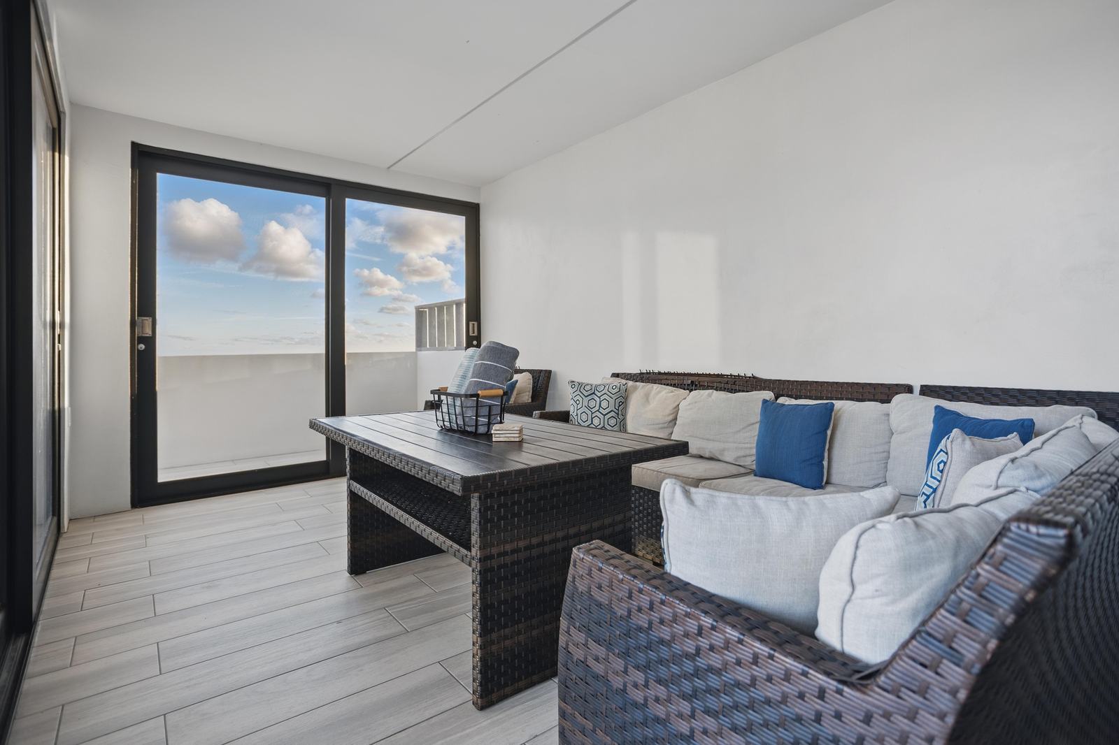 Salón techado al aire libre con sofás y vista al mar