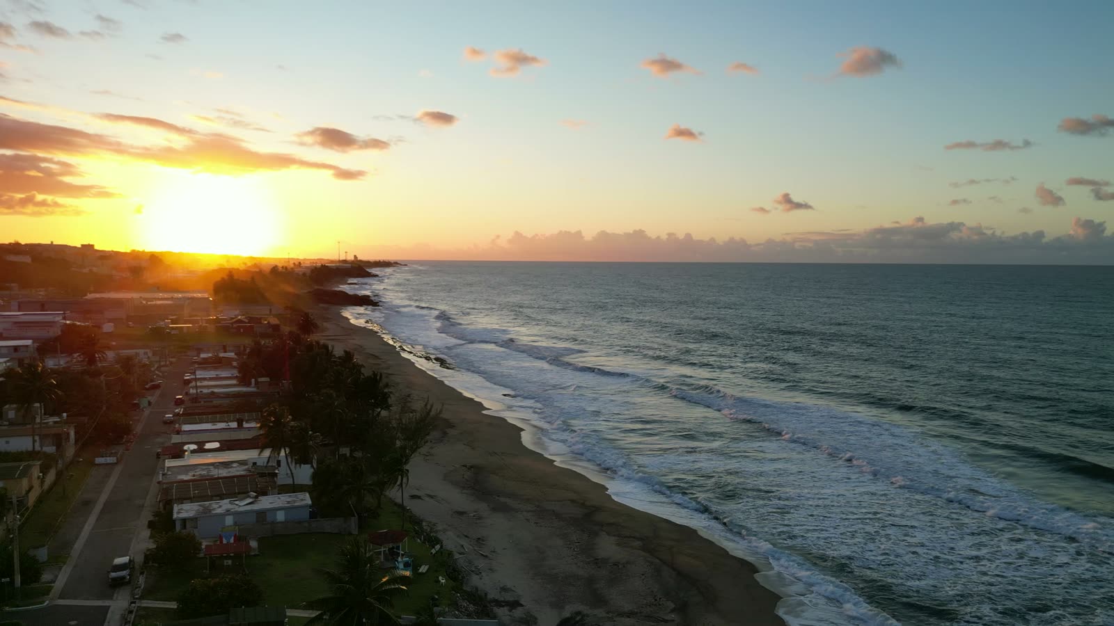 Vista aérea de la costa de Arecibo al atardecer, con el sol sobre el Atlántico